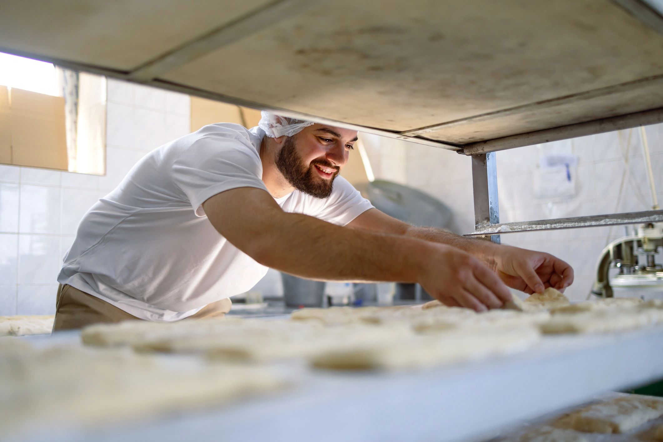 Baker preparing dough for baking bread in a professional kitchen