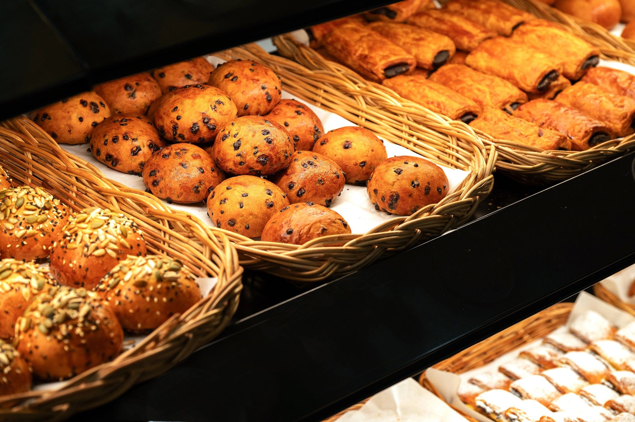 Fresh pastries in a wicker basket on a bakery counter